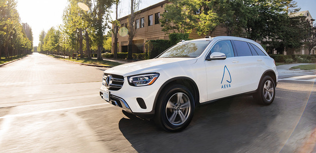 White car with branded blue Aeva logo driving on the road